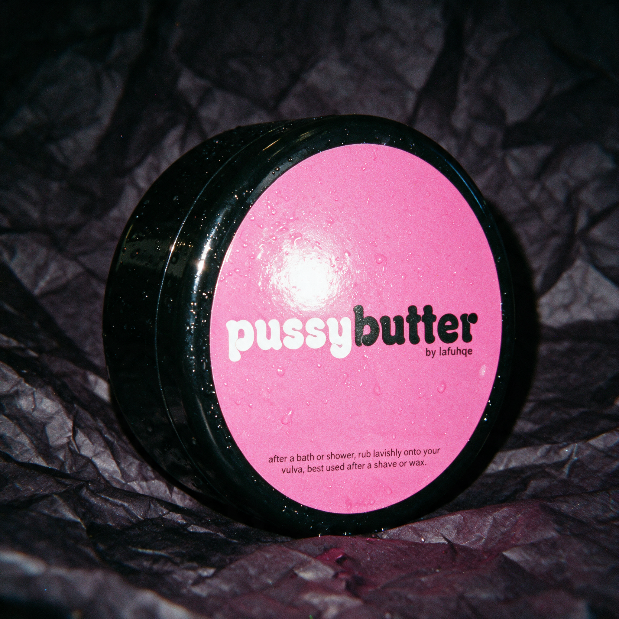 PoosyButter moisturizing vulva buttercream photographed on near-black plum backdrop