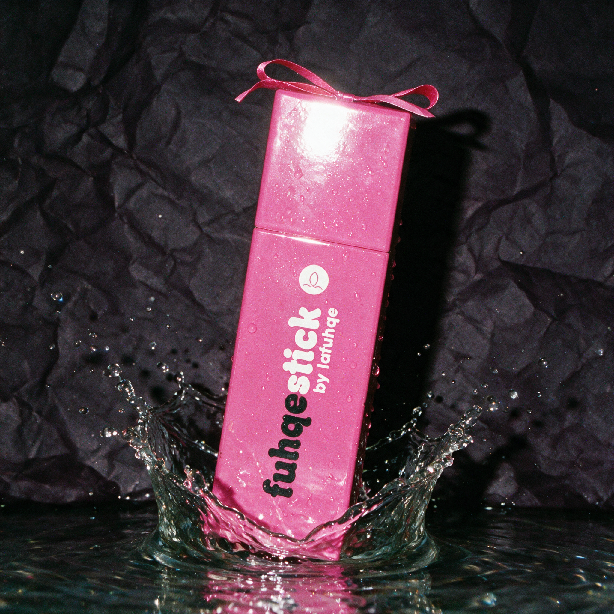 Fuhqe Stick box with splash photographed on near-black plum backdrop