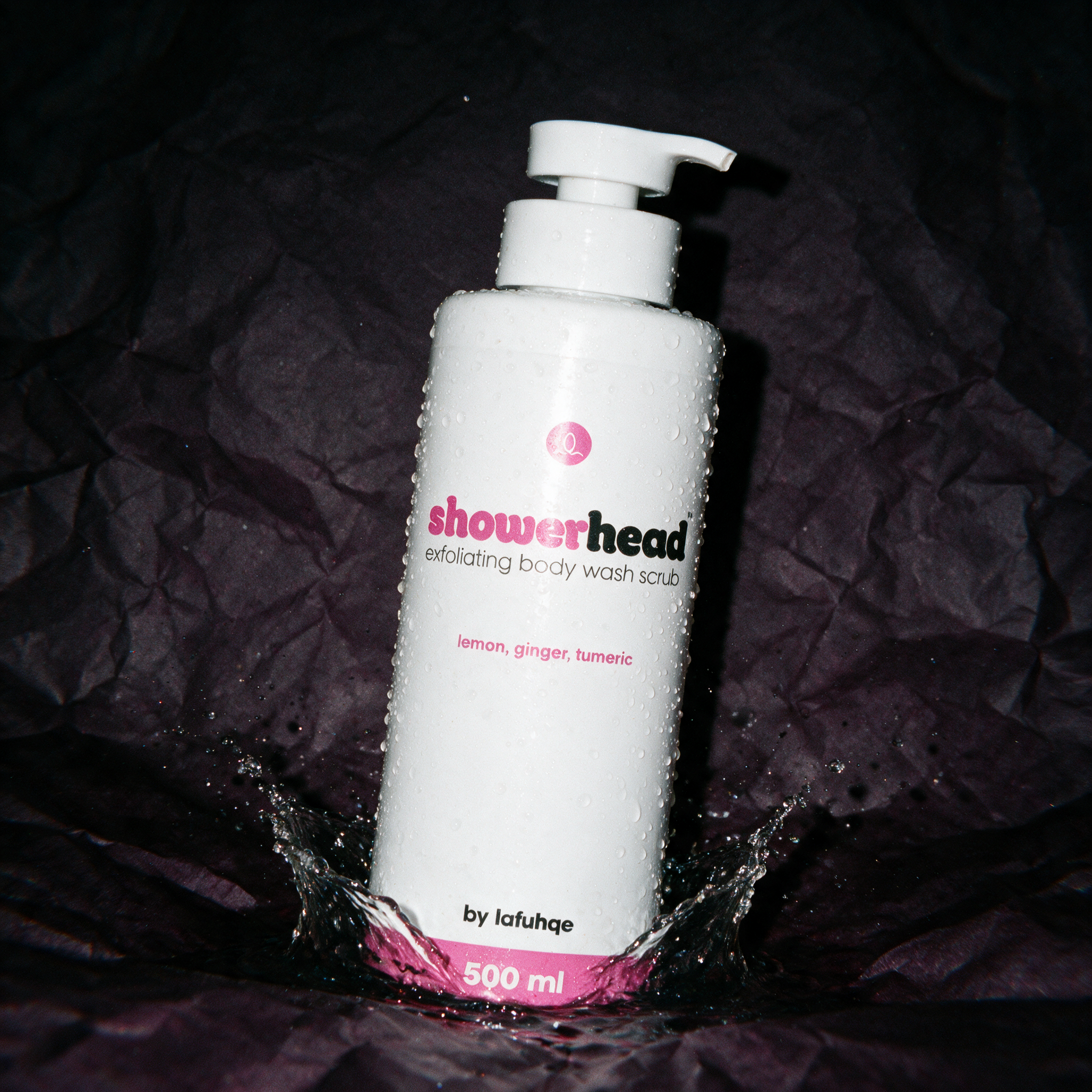 Shower Head exfoliating body wash gel with splash on deep plum backdrop